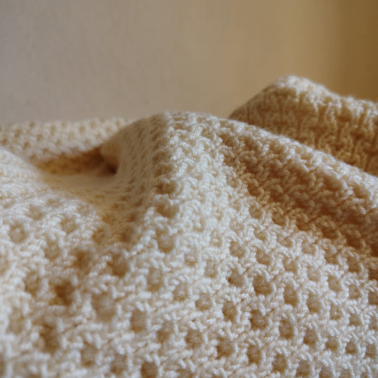 Nahaufnahme einer in Österreich gestrickten Babydecke aus Merinowolle 